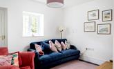 The second sitting room area has a plush navy blue sofa and wonderful Cornish-inspired artwork. - Thumbnail Image