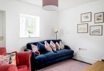 The second sitting room area has a plush navy blue sofa and wonderful Cornish-inspired artwork.