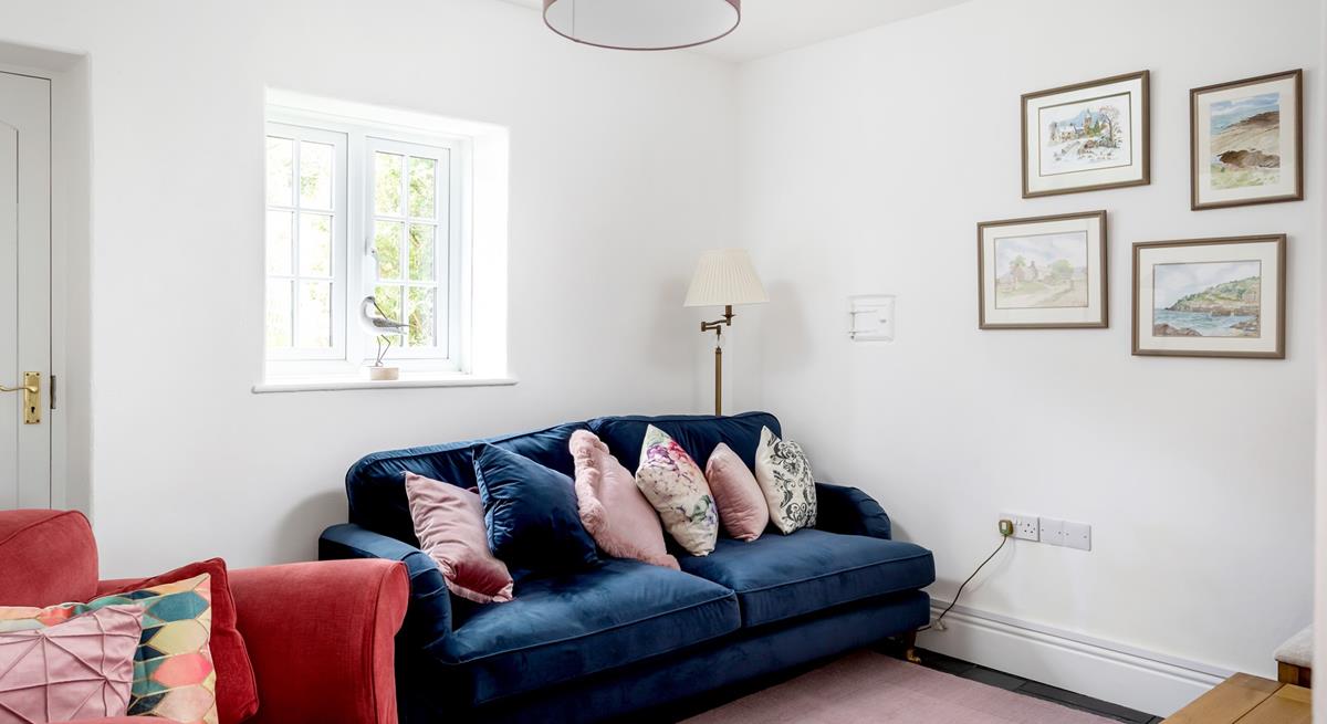 The second sitting room area has a plush navy blue sofa and wonderful Cornish-inspired artwork.