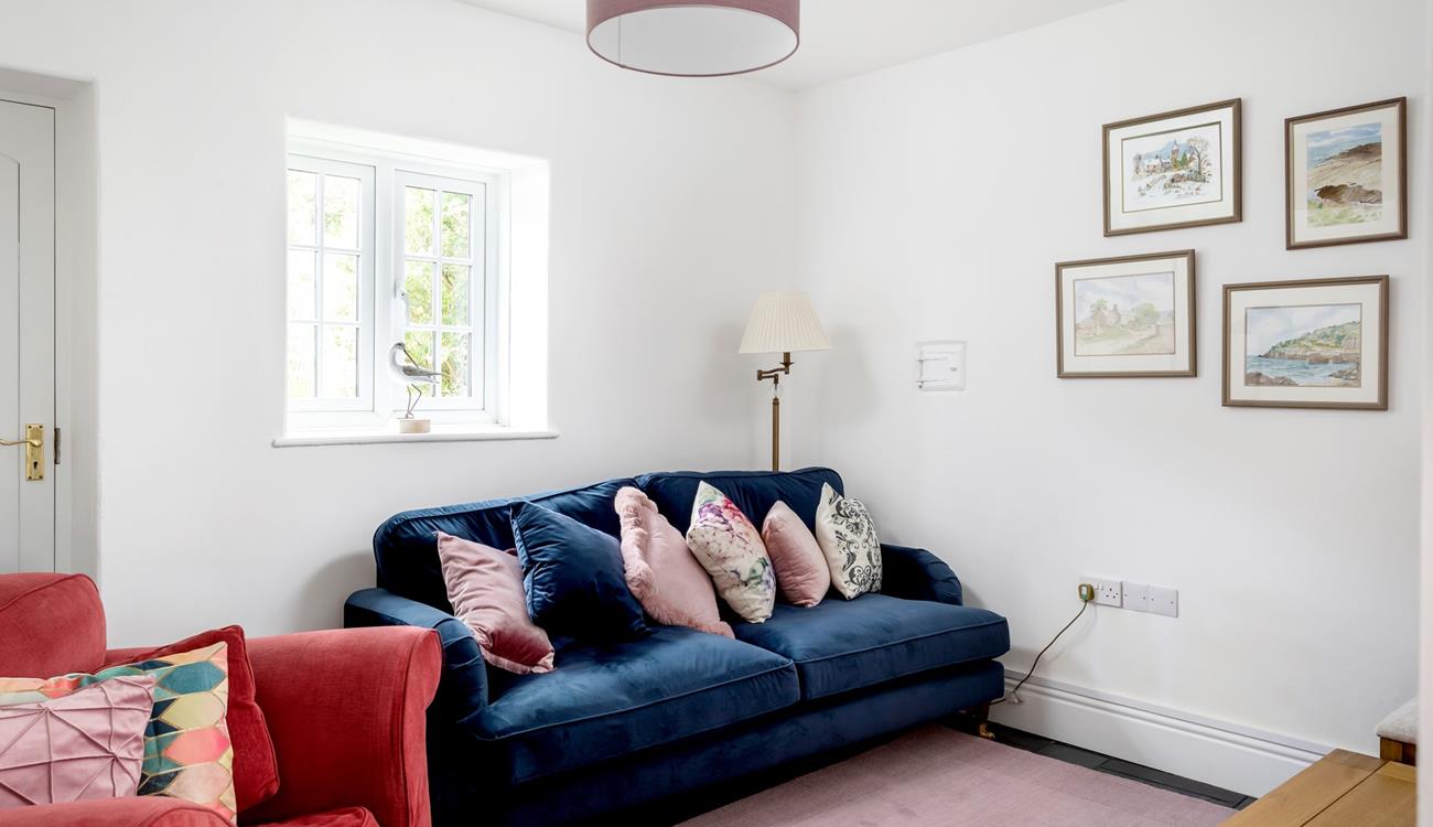 The second sitting room area has a plush navy blue sofa and wonderful Cornish-inspired artwork.