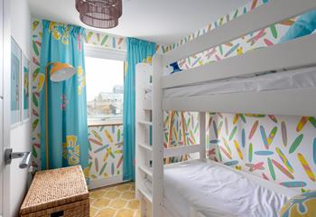 The bespoke wallpaper and curtains give the bunk bedroom a fun feel for the children. 