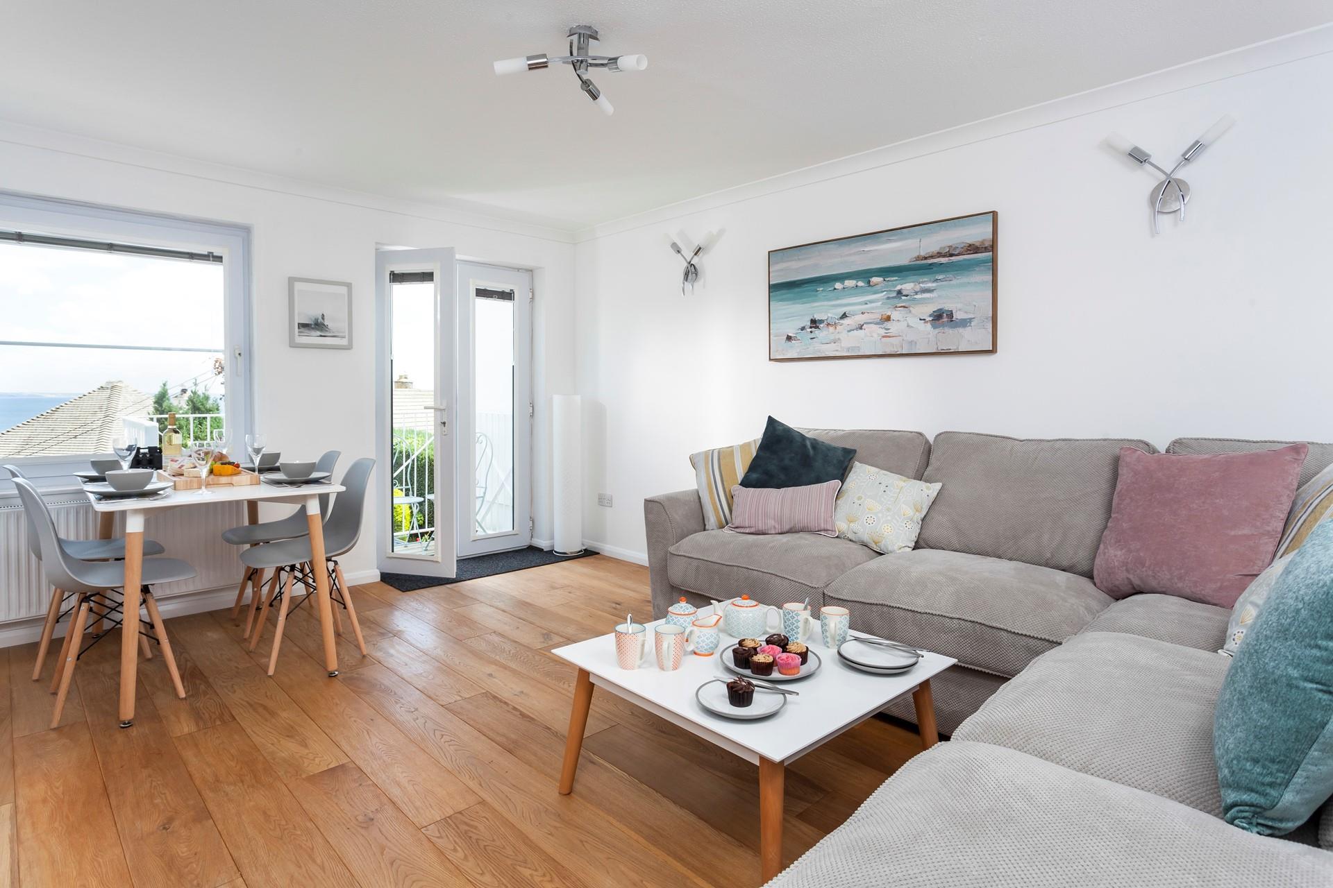 Enjoy the open living area with sea views from the sofa, dining area, and balcony.