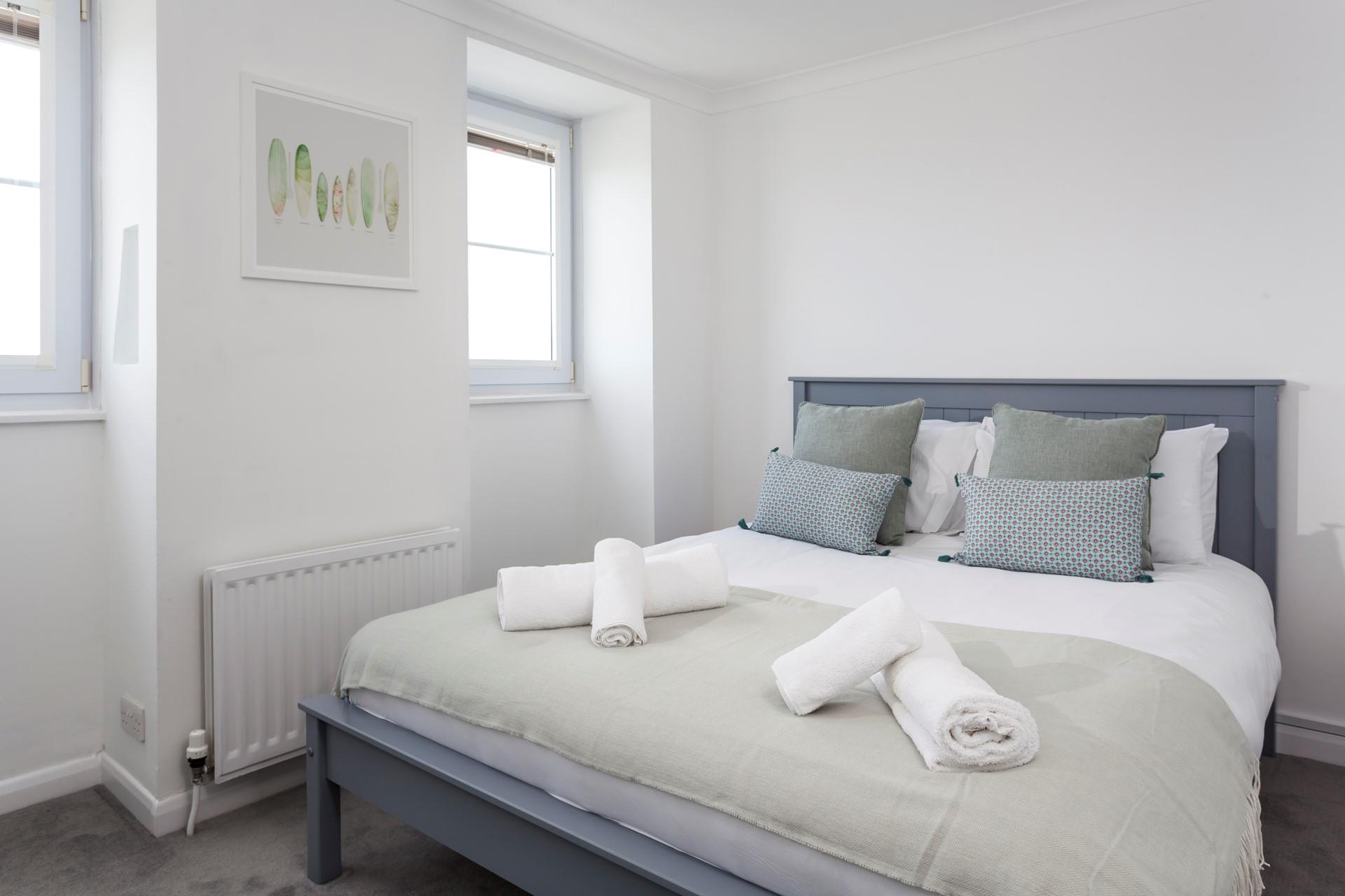 Enjoy a peaceful night's sleep in the calming, coastal bedroom.