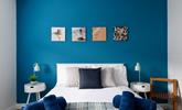 The bedroom has a blue theme reflecting the seaside location. - Thumbnail Image