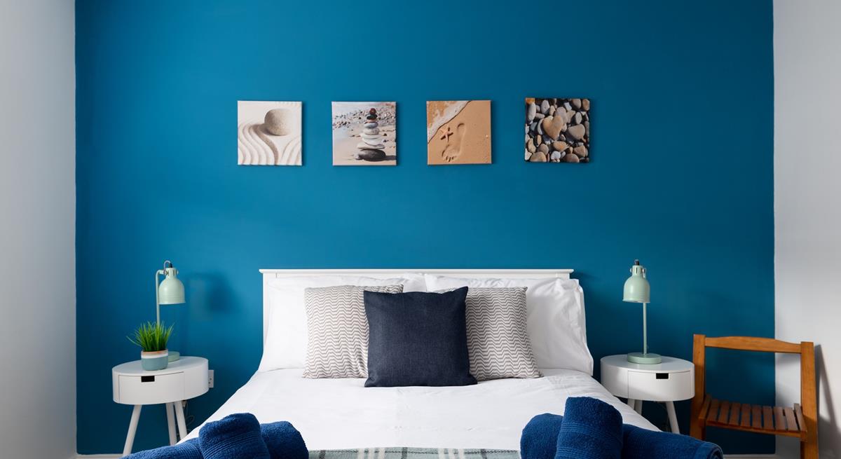 The bedroom has a blue theme reflecting the seaside location.