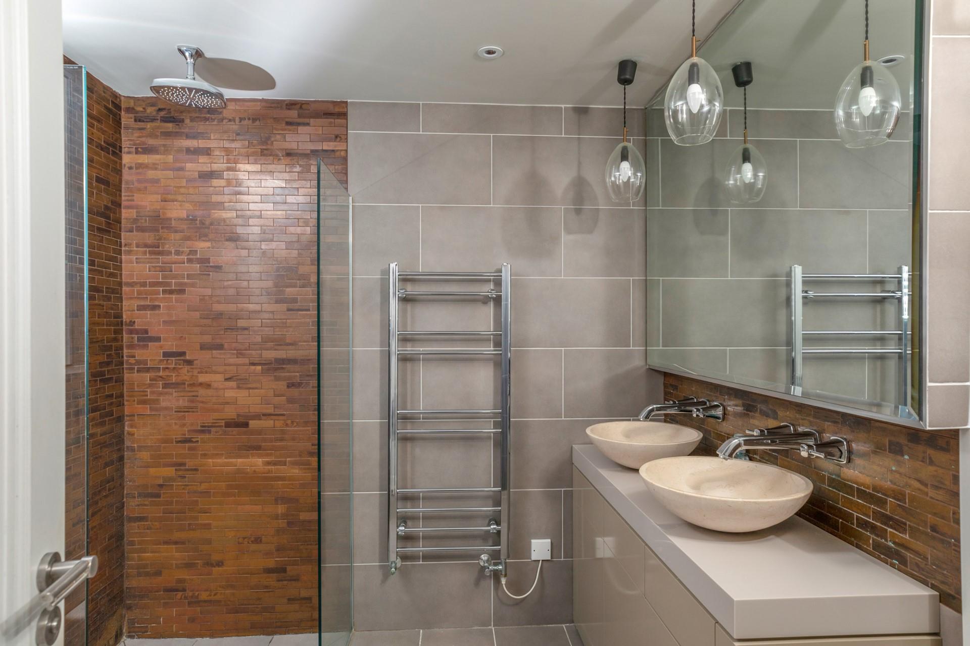 The chic bathroom boasts his and hers sinks and a luxurious shower.