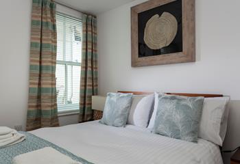 The bedroom features cosy interiors and pastel colours.