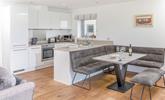 The kitchen is modern and sleek with space for the whole family to sit around the dining table. - Thumbnail Image