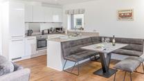 The kitchen is modern and sleek with space for the whole family to sit around the dining table.
