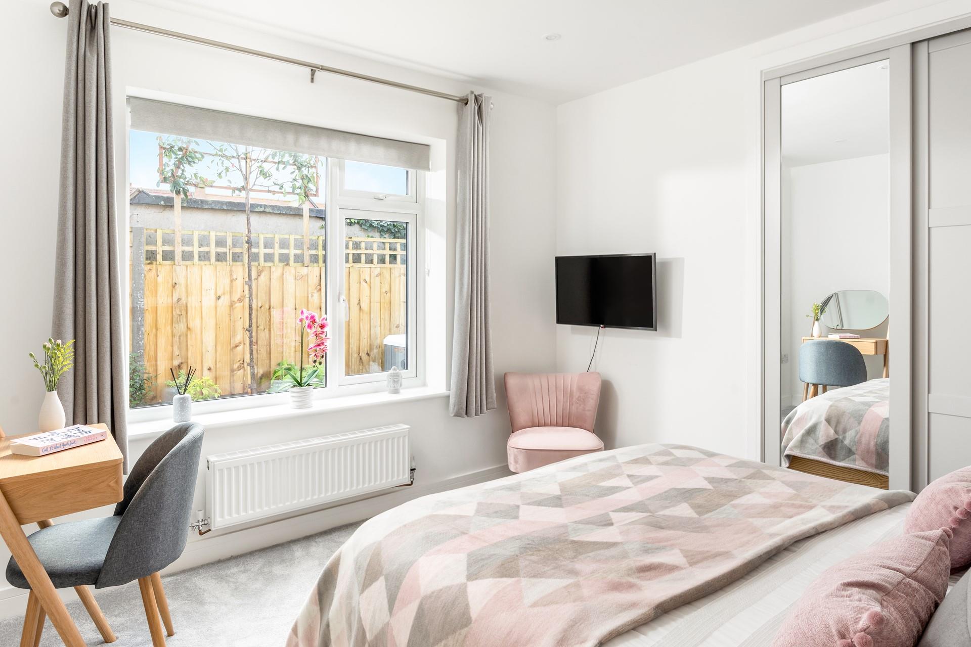 Bedroom 1 has blush pink decor and a spacious king size bed for a dreamy night's sleep.