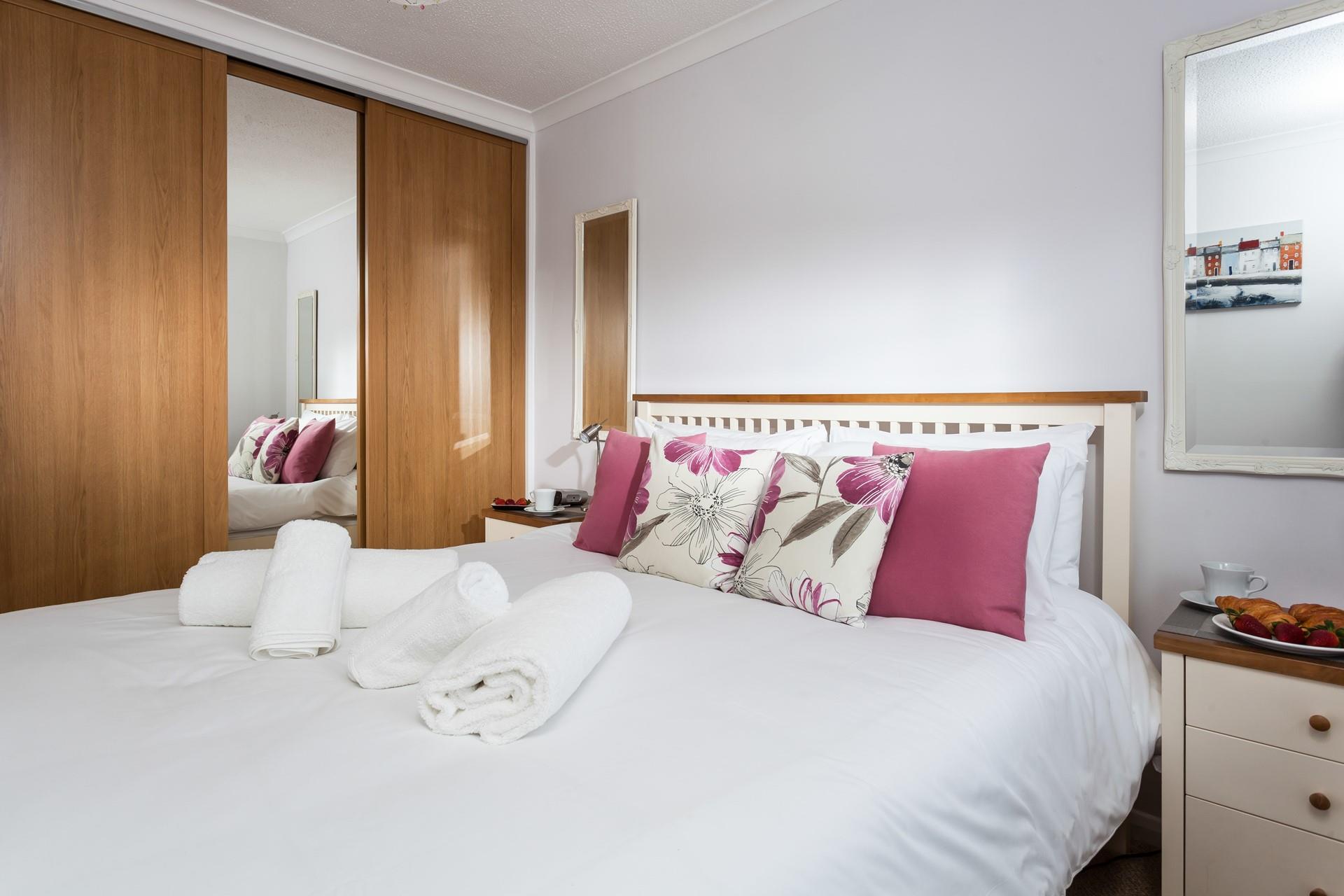 Bedroom 2 is decorated with lovely fuchsia pink cushions.