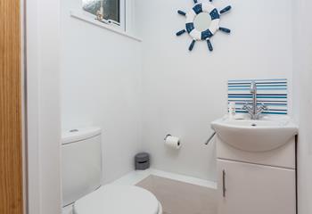 The downstairs cloakroom has a WC and basin and is decorated with a blue and white theme.