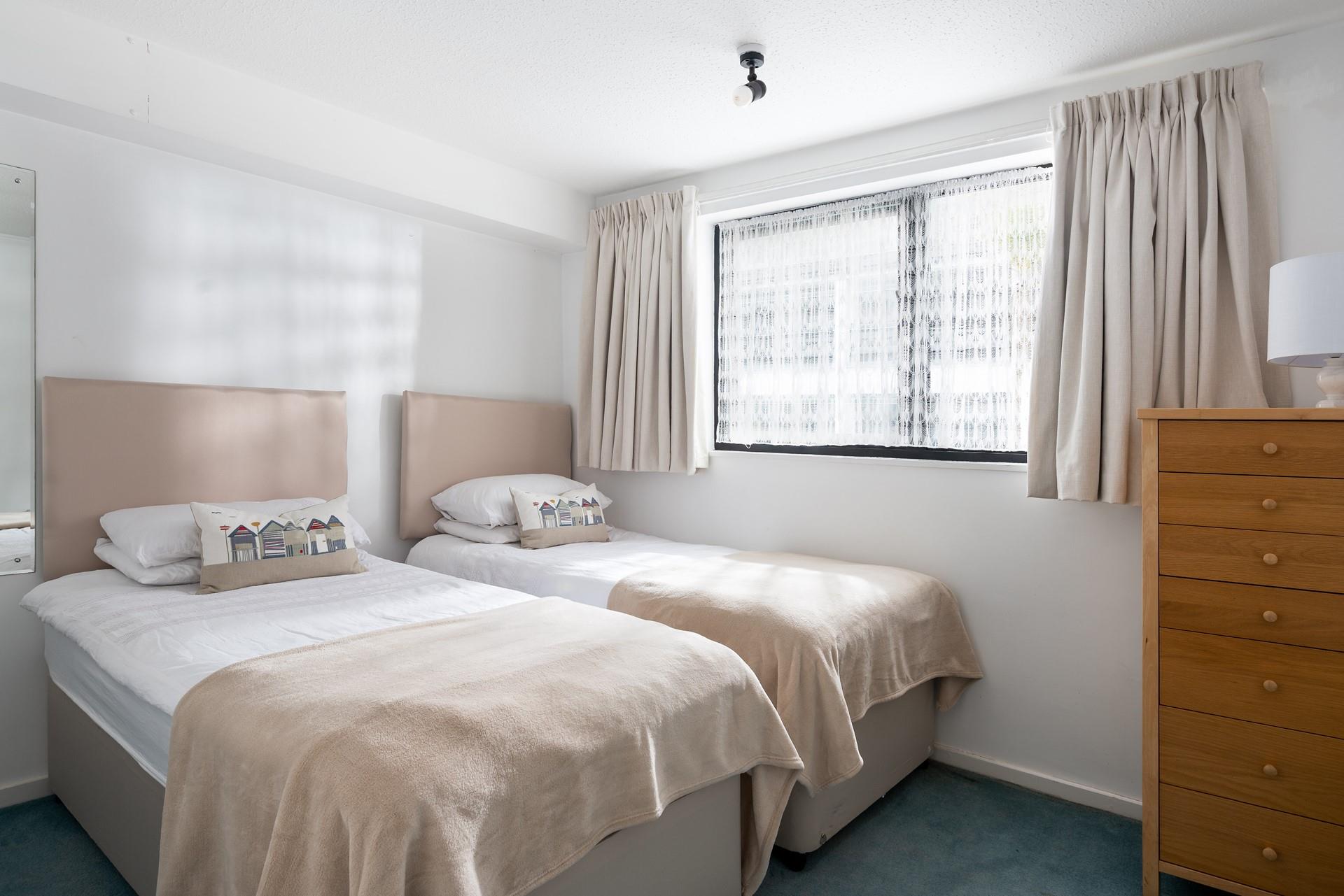 Bedroom 2 has twin beds perfect for adults or children to rest after an exhausting day exploring the coastline.