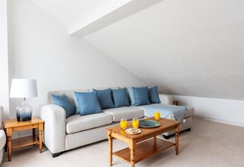 The light sitting room is decorated with a blue colour scheme to reflect the close proximity to the sea.