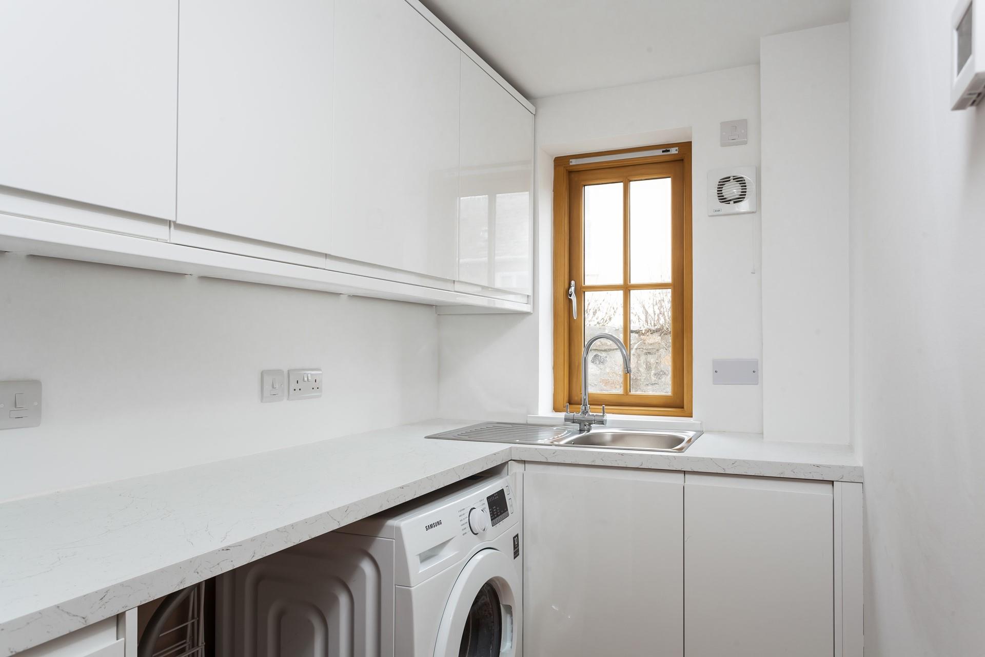 The utility room features a washing machine to wash all your beachwear.