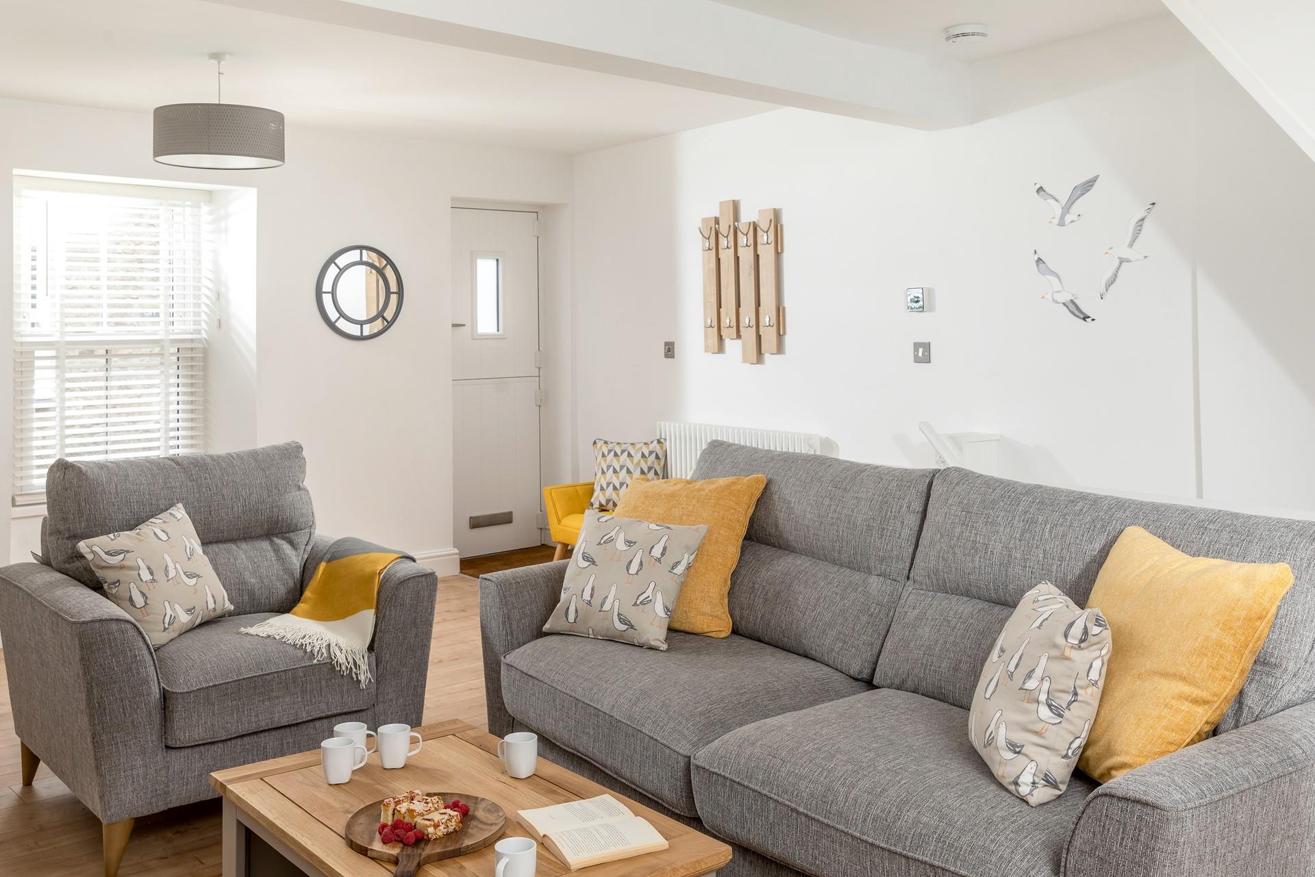 The spacious sitting room features grey interiors creating a relaxing space for up to 6 people.
