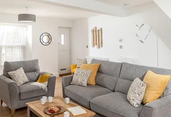 The spacious sitting room features grey interiors creating a relaxing space for up to 6 people.