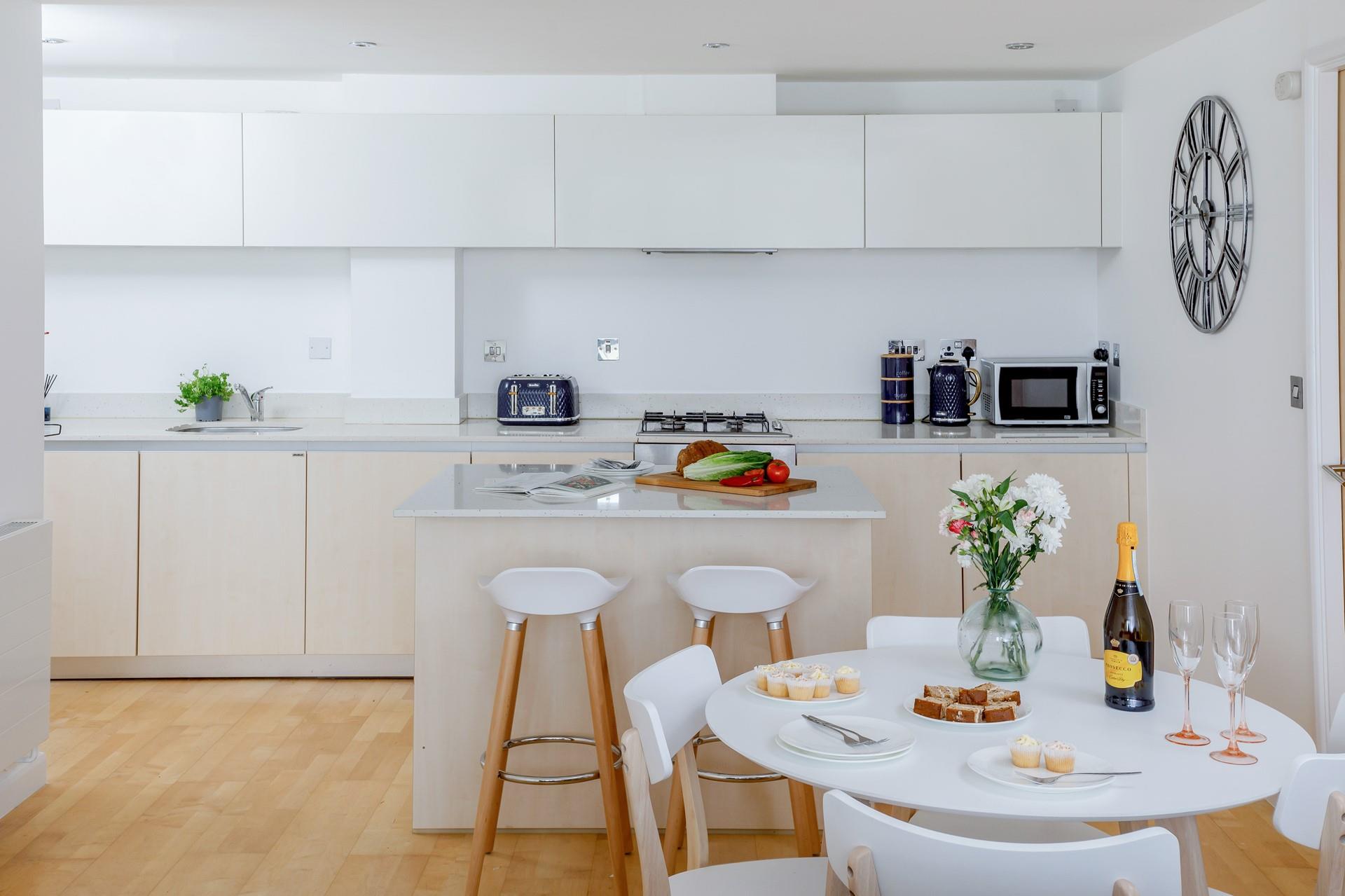 Crisp white walls and kitchen make a refreshing and light space.