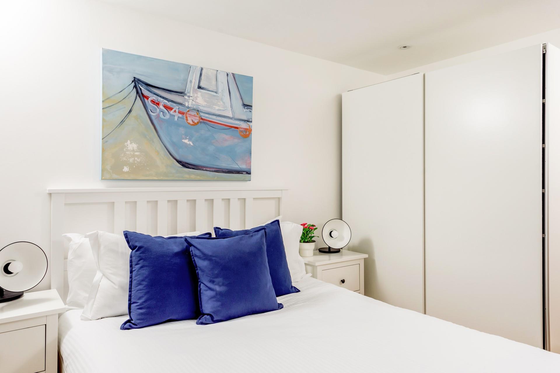 Bedroom 1 features beautiful artwork reflecting the seaside location.