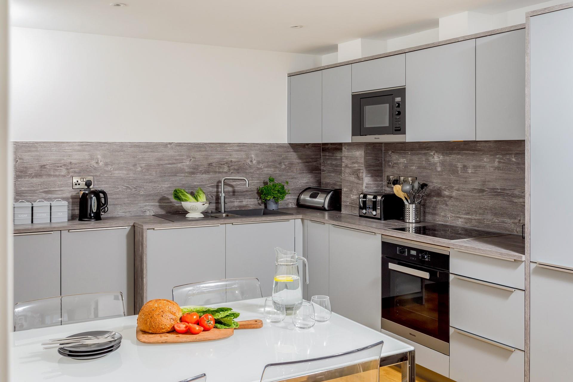 The sleek and modern kitchen is well-equipped for all your culinary needs.