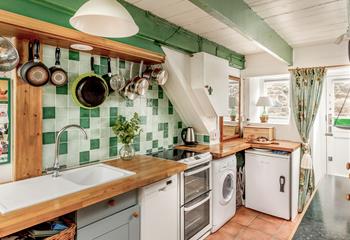 The kitchen has green tiles and is in keeping with the cottage feel.