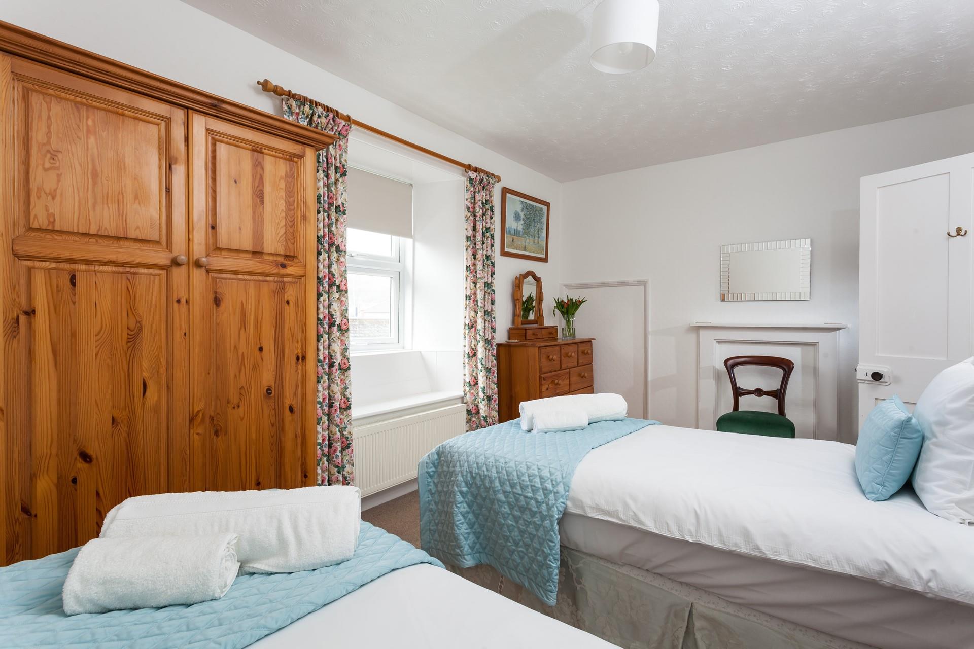 Bedroom 2 has twin beds perfect for adults or children to enjoy a relaxing night's sleep.