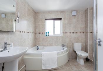 Relax and unwind in the corner bath after a day walking the coast path.