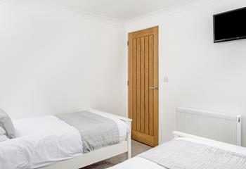 Bedroom 2 has comfortable twin beds and bright white walls.