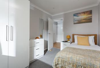 Bedroom 3 has a bright pop of colour with the yellow decor and sunset artwork.