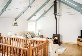The comfortable living room has a woodburner for cosy nights in.