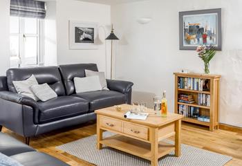 The comfortable sitting room has leather sofas and oak flooring, a great base to come back to.