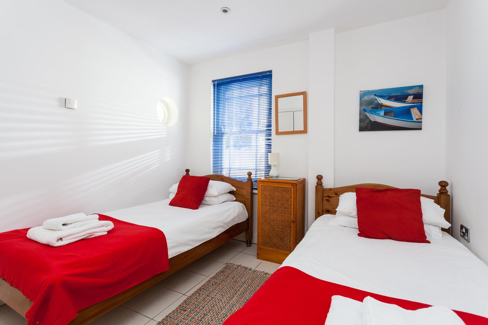 Bedroom 3 has twin beds and bright pops of colour.