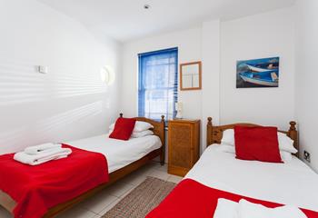 Bedroom 3 has twin beds and bright pops of colour.