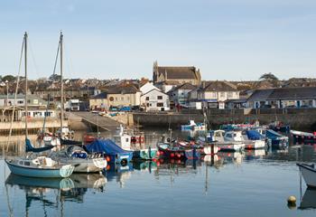 As the sun rises, the boats bobbing on the glistening water make for the perfect backdrop.