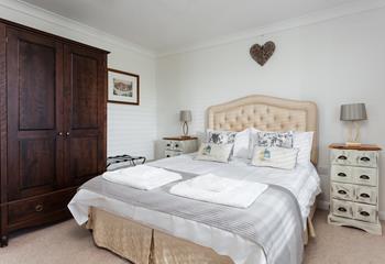 The comfortable bedroom has storage space and homely decor.