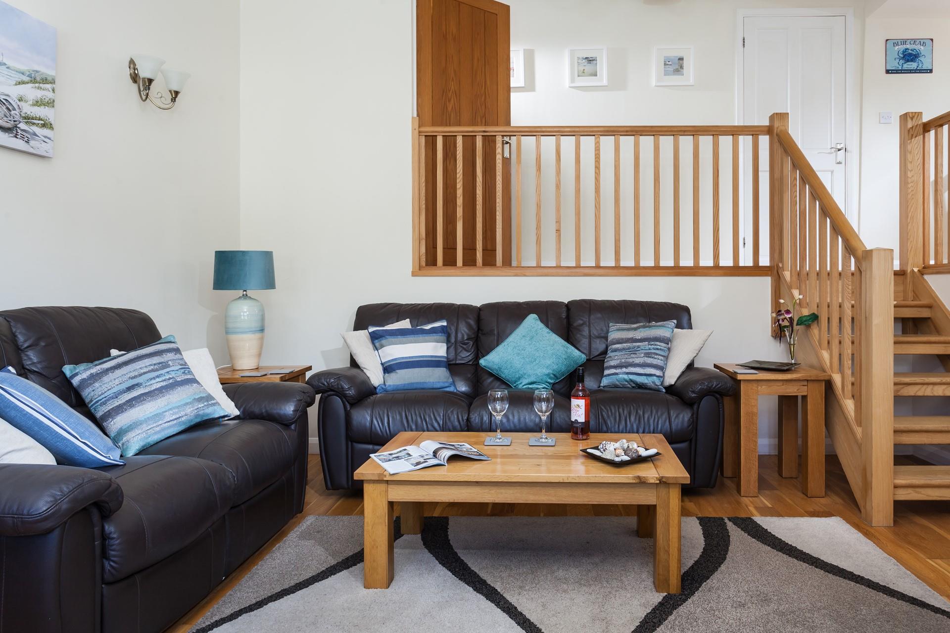The spacious living room has leather sofas and oak flooring and is a lovely space to relax.