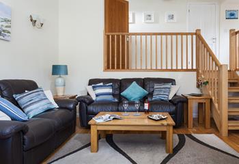 The spacious living room has leather sofas and oak flooring and is a lovely space to relax.