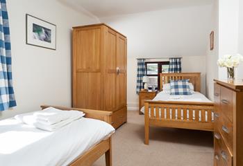 The twin room is decorated with blues and whites to reflect the proximity to the ocean.