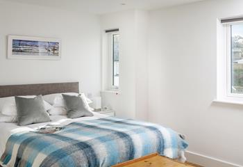 The main bedroom has a spacious king size bed and calming blue tones.