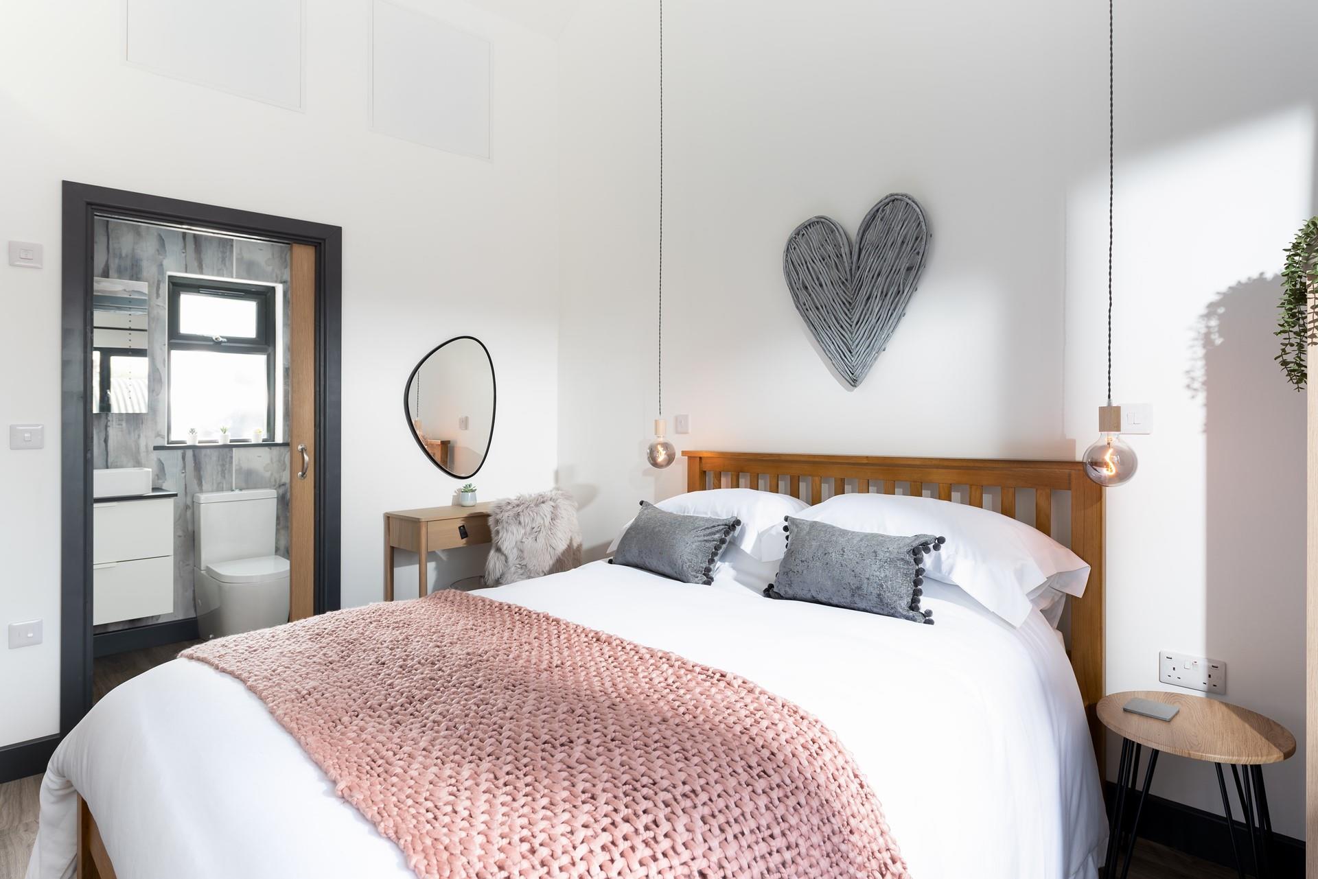 The pink and grey decor makes for a luxurious place to rest your head each night.