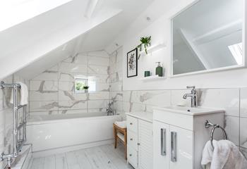 The family bathroom has stylish marble effect tiles and a heated towel rail for warm fluffy towels.
