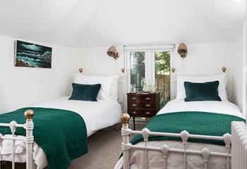Cosy twin beds in bedroom 3 decorated with lovely teal cushions and blankets.