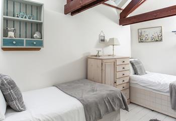 Bedroom 2 has twin beds and beach-inspired decor reflecting the seaside location.
