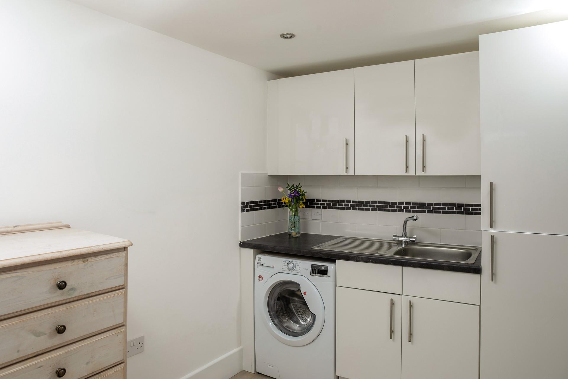 The utility room has a washing machine and handy storage for surfboards or bikes.