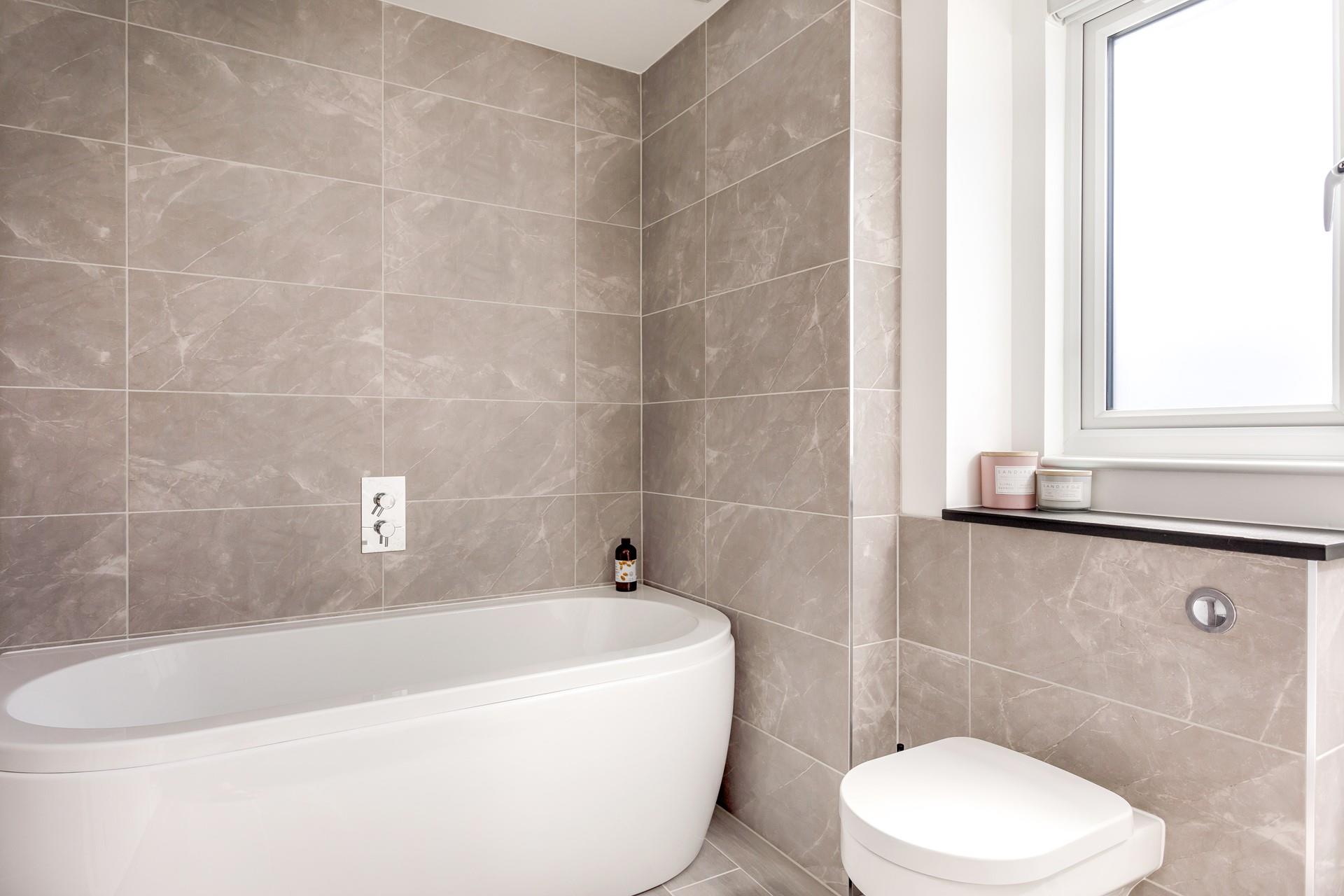 The modern bathroom has a deep bath to sink into on a relaxing evening.