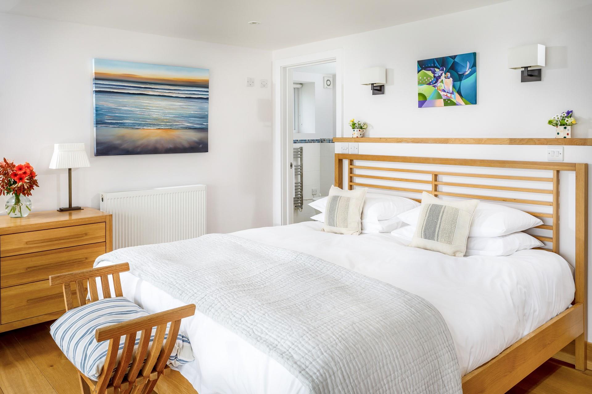 The master suite has calming tones and bright artwork.