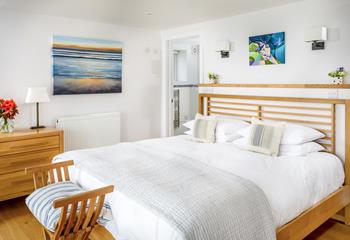 The master suite has calming tones and bright artwork.