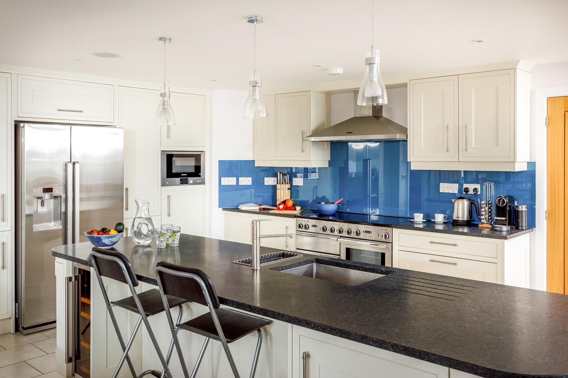 The kitchen is modern and sleek with the added bonus of an ice maker in the fridge.