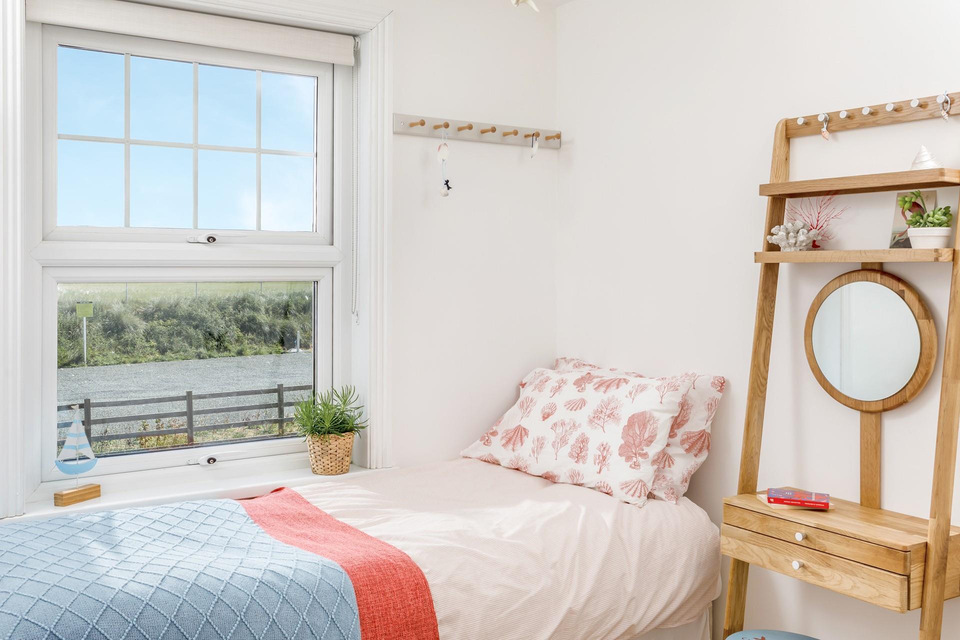 Bedroom 4 has coral-themed bedding perfect for seaside lovers.