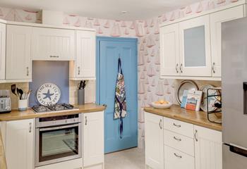The kitchen is well-equipped featuring quirky sailing boat wallpaper.